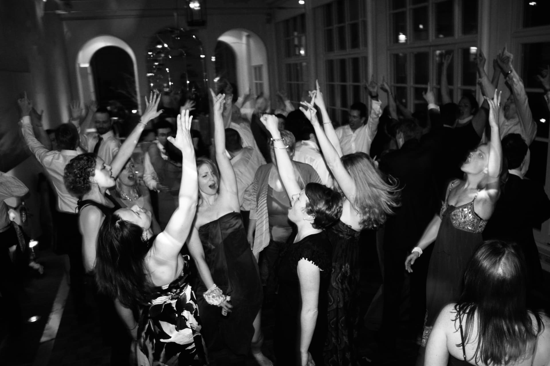 A dance floor full of people dancing with their arms in the air!