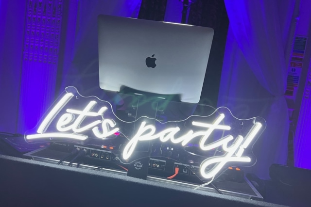 Let's party neon sign with an Apple Macbook Air